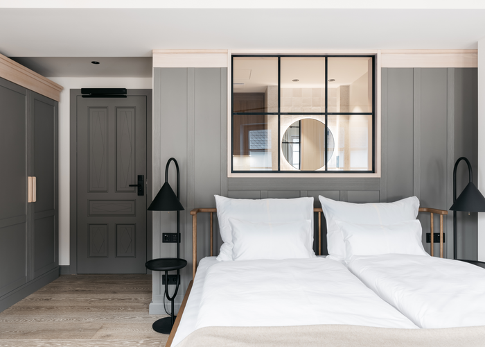 Die grau lackierten Türen und Wandvertäfelungen sowie die gebeizten Vollholzmöbel geben den Zimmern in den oberen Stockwerken eine heimelige Atmosphäre. | © Refugium Lunz / Gregor Hofbauer