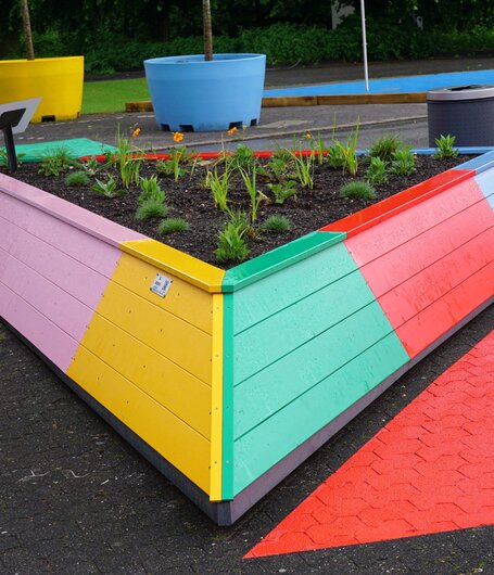 Die Dreieck-Hochbeete erstrahlen dank Lignovit Terra-Color von ADLER in den Logo-Farben der Landesgartenschau Neuss.  | © August Bruns GmbH & Co. KG