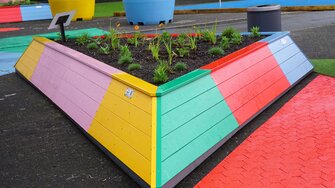Die Dreieck-Hochbeete erstrahlen dank Lignovit Terra-Color von ADLER in den Logo-Farben der Landesgartenschau Neuss.  | © August Bruns GmbH & Co. KG