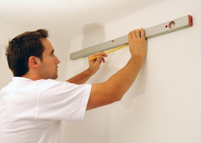 Abkleben: Markieren Sie mit Wasserwaage und Maßband die entsprechende Fläche und kleben Sie entlang der Hilfslinien die Fläche ab, die nicht gestrichen wird.