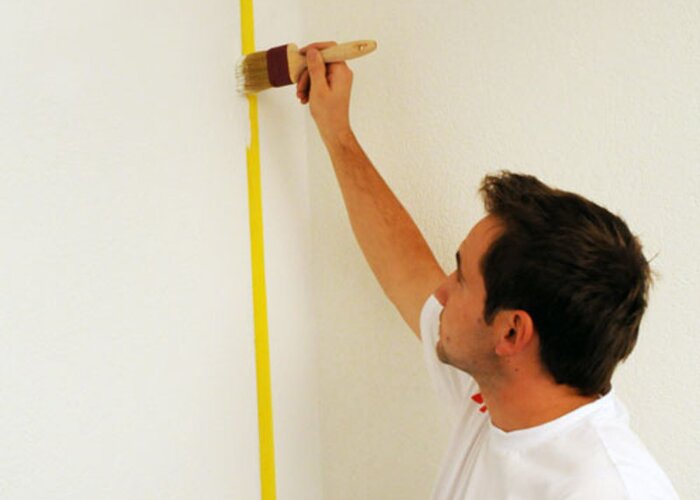 Hohlräume stupfen: Damit keine Farbe unter das Klebeband läuft, stupfen Sie das Klebeband mit einem Pinsel und weißer Farbe ab.